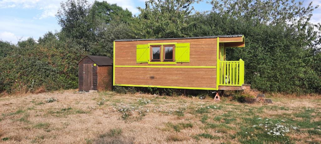 a small house sitting on top of a field at Une roulotte dans les vignes Ancenis in Vallons-de-l'Erdre