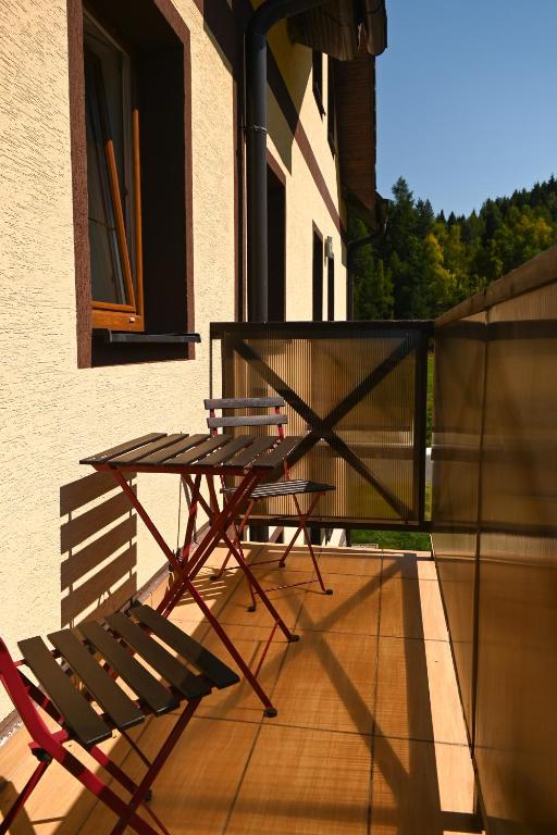 a table and a chair sitting on a balcony at Apartman pri vleku in Telgárt