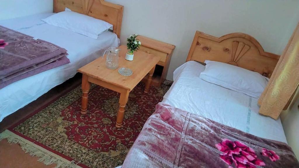 a small room with two beds and a table with a table at Ibrahim lodge restaurant in Astor