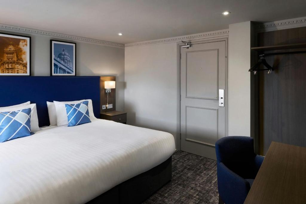 a bedroom with a large bed and a blue headboard at Four Points Flex by Sheraton Nottingham in Nottingham