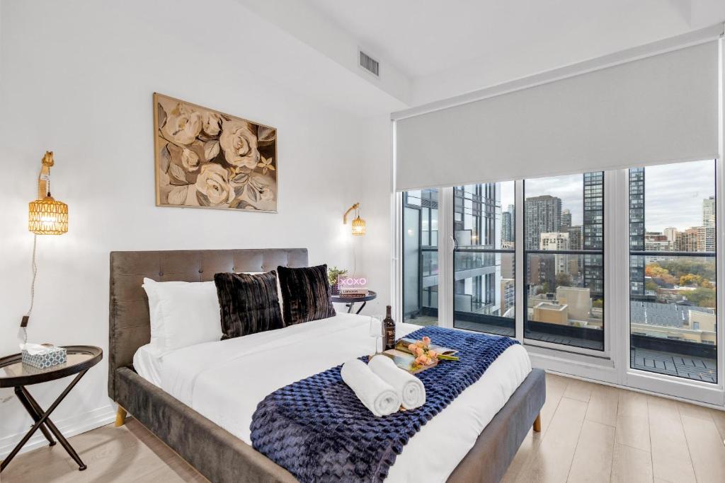 a bedroom with a bed and a large window at Filmos Hotel and Suites in Toronto