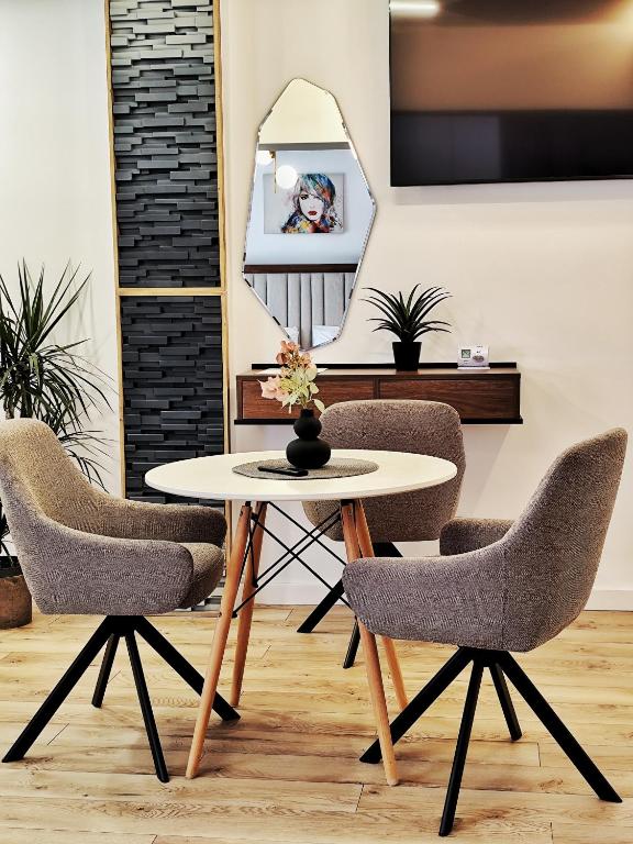 a table and chairs in a room with a mirror at Verso Studio in Curtea de Argeş