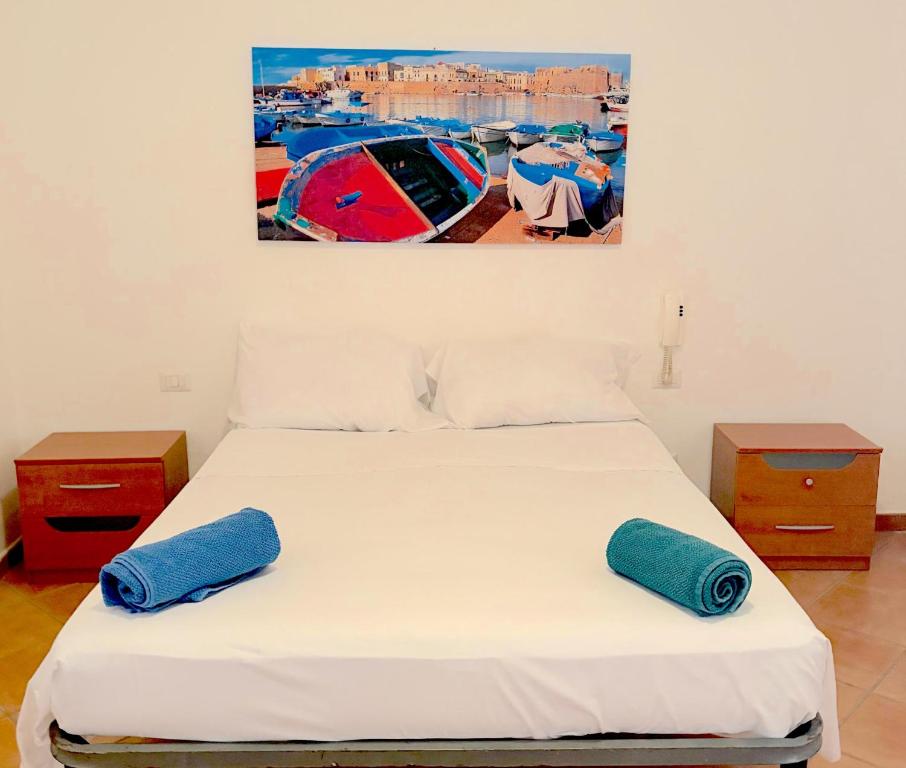 a bedroom with a bed with two blue pillows on it at Cuttin Apartment in Gallipoli