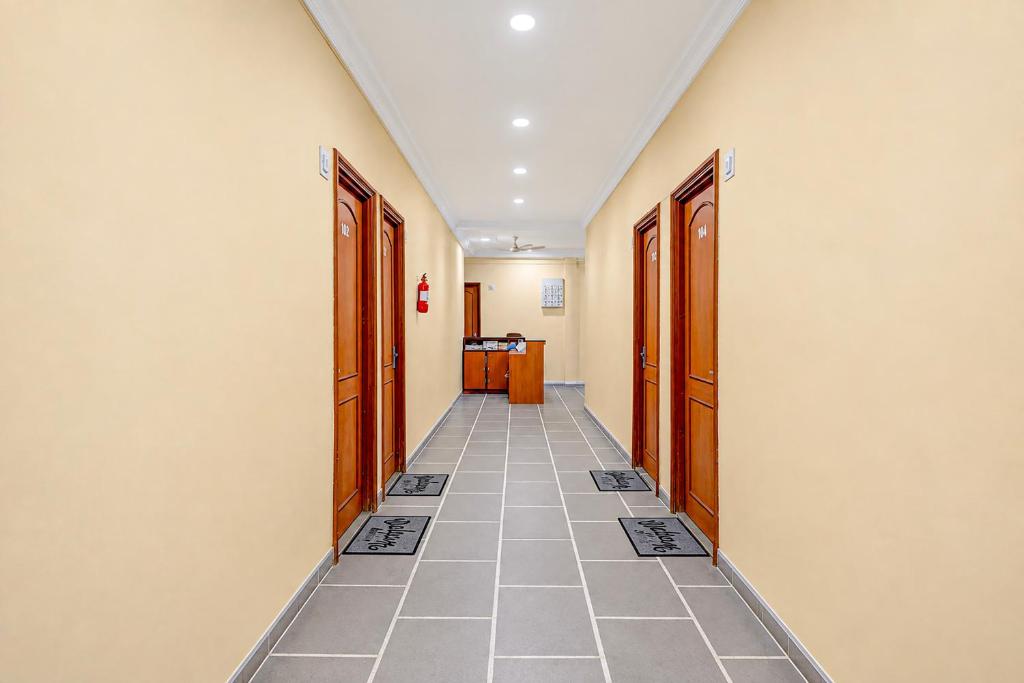 an empty hallway with doors and a tile floor at SPOT ON Hotel Silver Spoon in Dhule