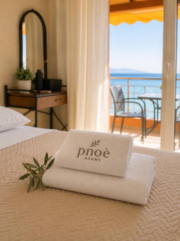 a hotel room with a towel on top of a bed at PNOÉ rooms in Ilia