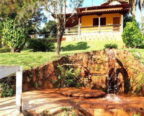 a water fountain in front of a house at Pousada Coqueiro Verde in Mateus Leme