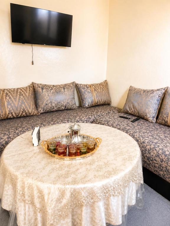 a living room with a table and a couch at Maison traditionnelle cadablabca centre in Casablanca