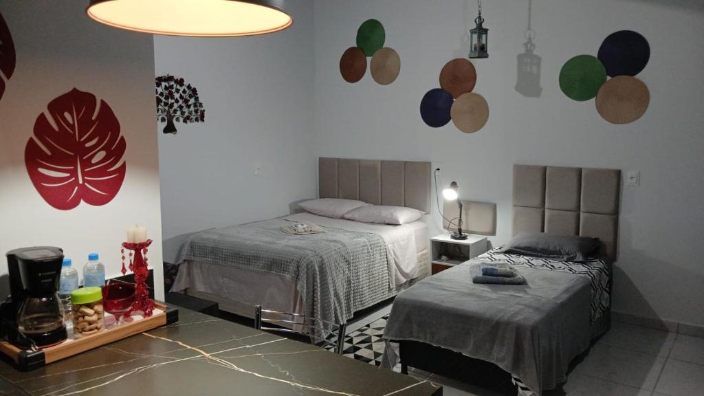 a bedroom with two beds and a table with a lamp at Ertal House in Blumenau