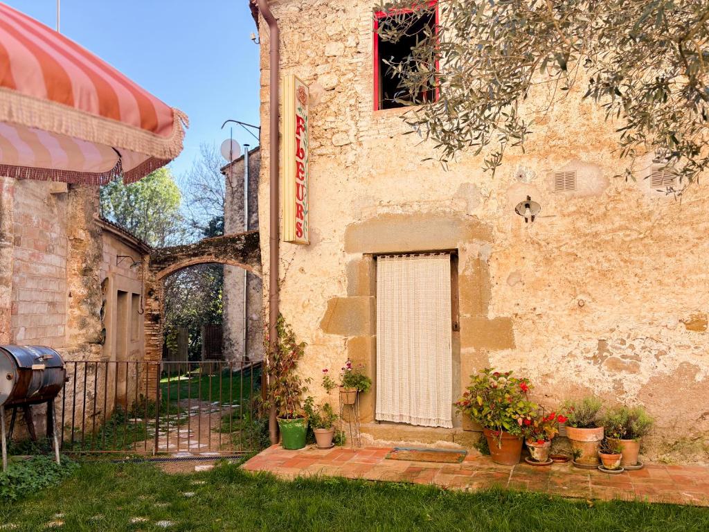 a building with a door and potted plants in front of it at Mas Ferrer Petit by 123ole in Sant Andreu del Terri