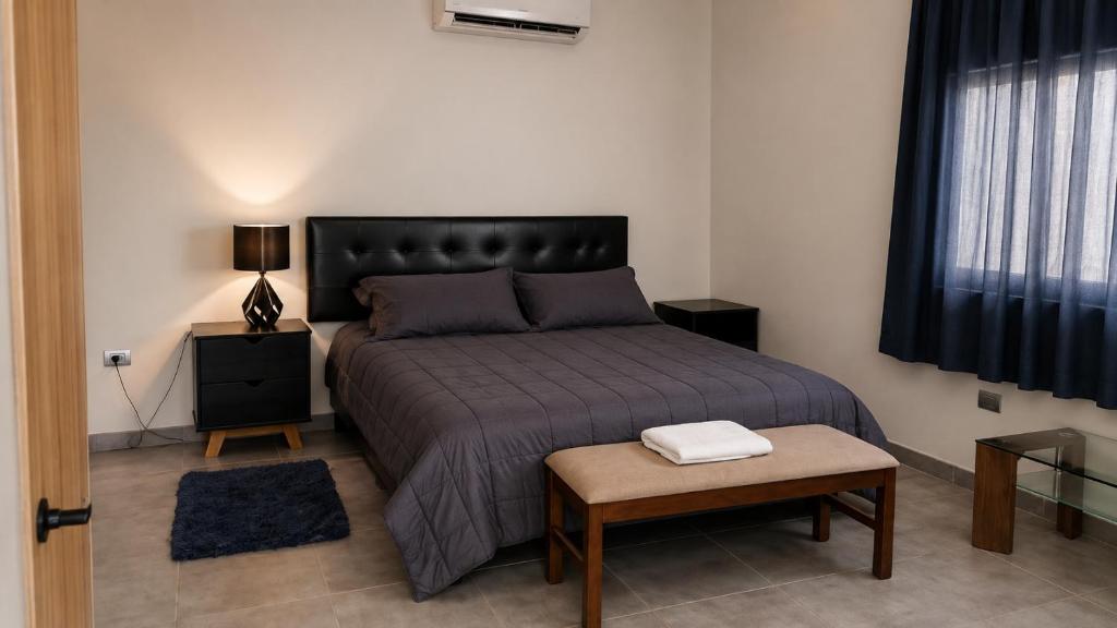 a bedroom with a bed and a table in it at Loft privado con alberca - Cama King in El Centenario