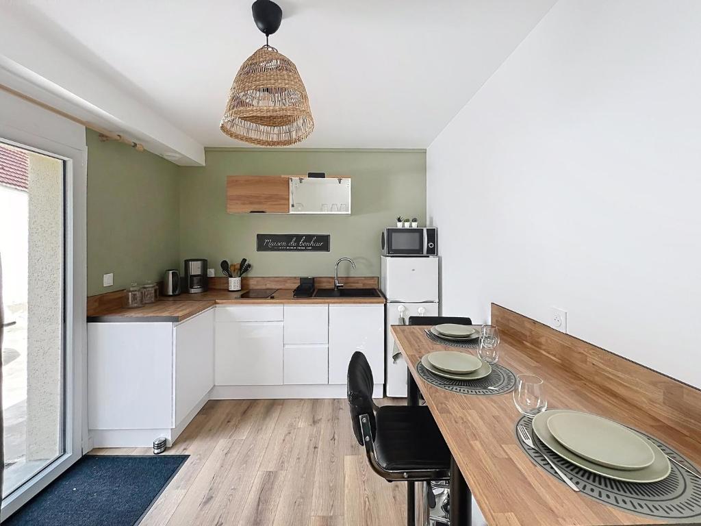 a kitchen with a wooden table with chairs and a dining room at Le Cosy Garibaldi in Sotteville-lès-Rouen
