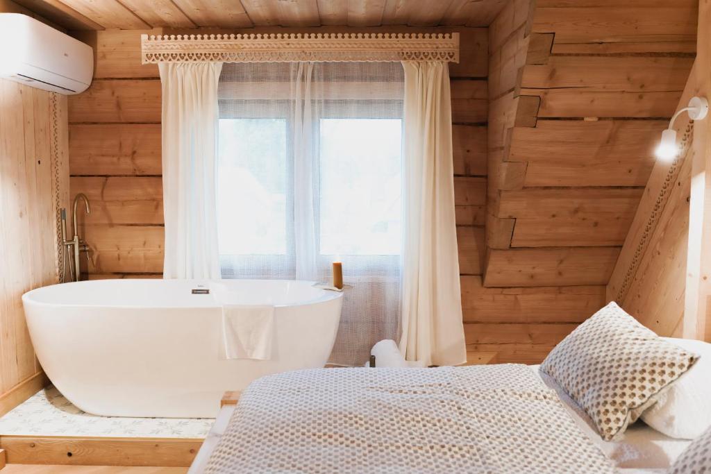 a bathroom with a large tub and a window at Willa Madejówka - Apartamenty z Widokiem na Góry i Wanną z Jacuzzi in Ząb