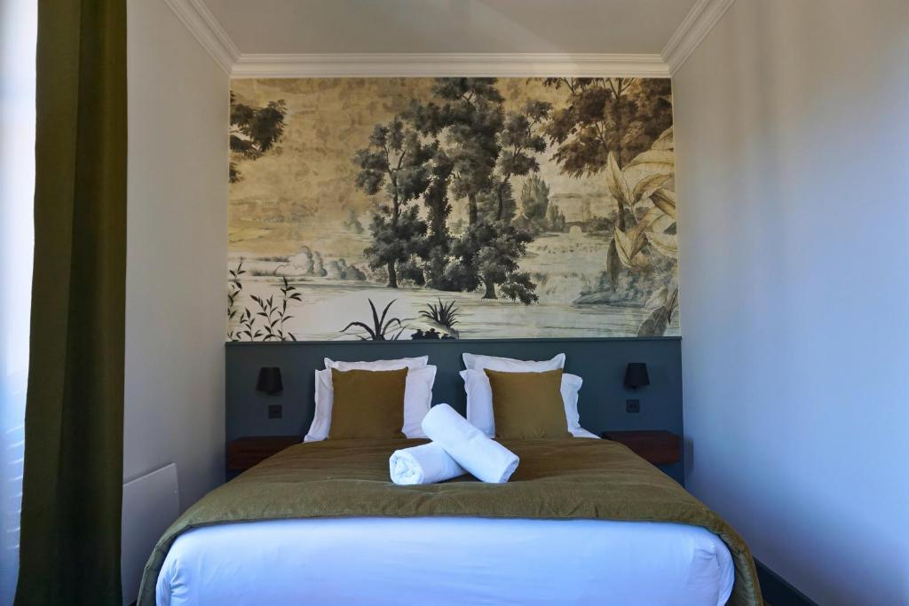 a bedroom with a bed with a painting on the wall at Maison Constant - Le Camélia in Autun