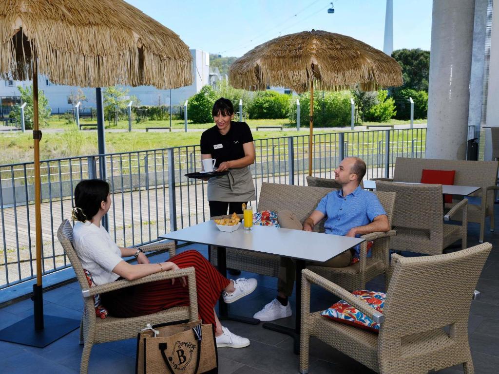 three people sitting at a table in a restaurant at Mercure Toulouse Sud in Toulouse