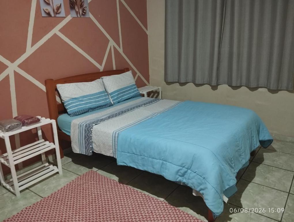 a bedroom with a bed and a table and a window at Casa cantinho da Rubi in Atibaia