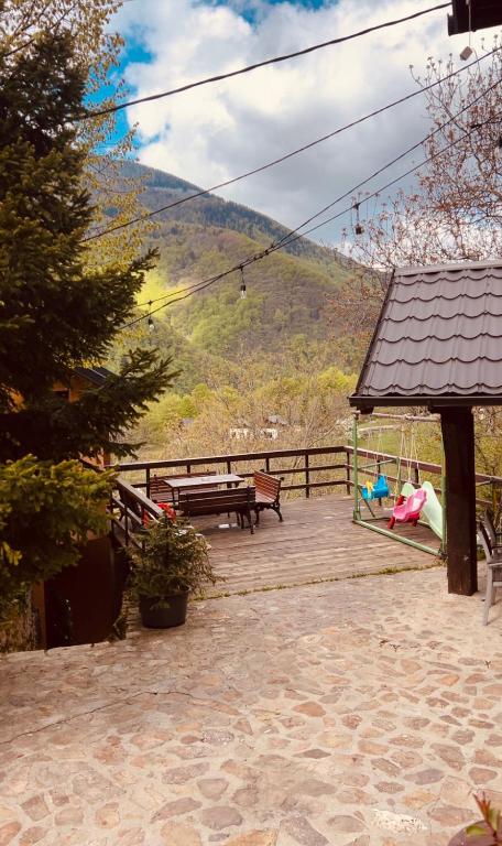 a wooden deck with a bench and a playground at Villa Albani in Peje