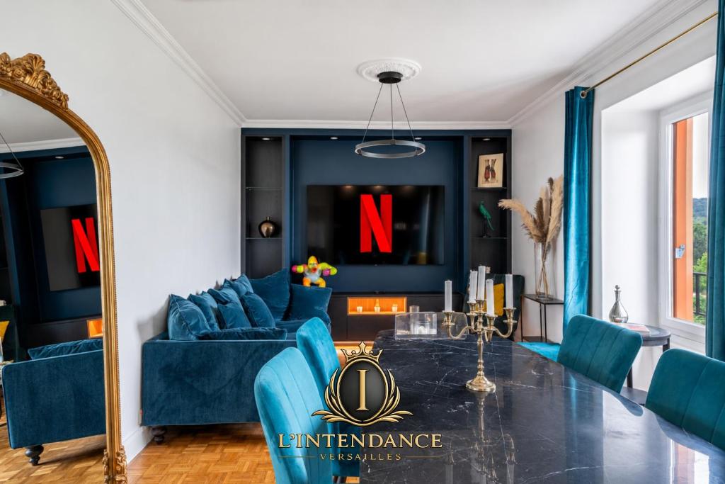a living room with blue furniture and a large mirror at Le Versailles Suite classé 3 étoiles Vue Château & Potager in Versailles