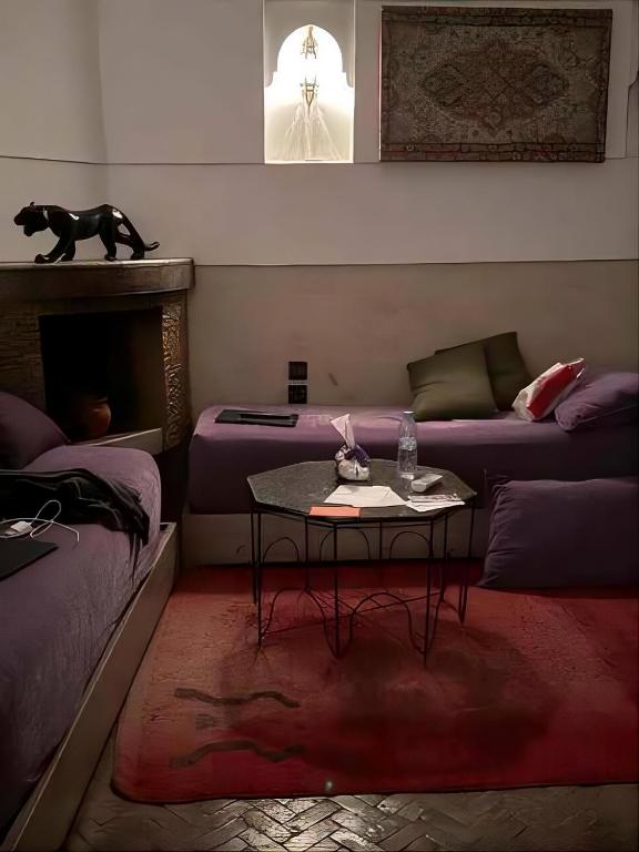 a living room with a table and a couch at Riad Khalid Zrika Marrakech in Marrakesh