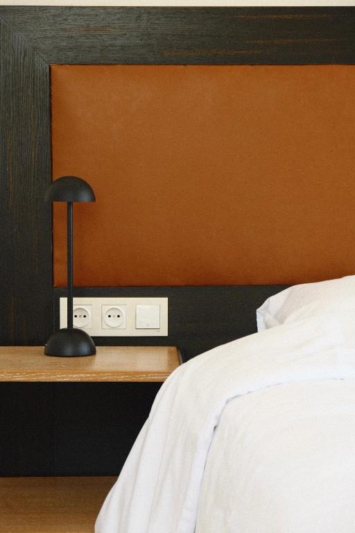 a bedroom with a bed and a desk with a lamp at Racha Roots Boutique House in Ambrolauri