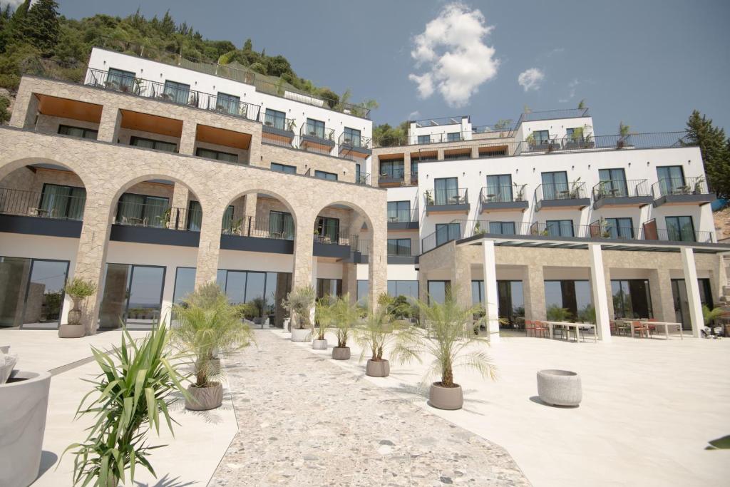 ein Gebäude mit Palmen in einem Innenhof in der Unterkunft Avaris Hotel in Dhërmi