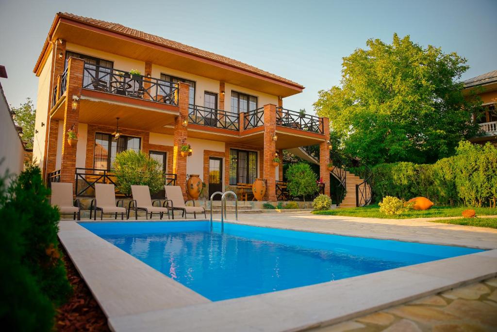 a house with a swimming pool in front of a house at Merebashvili Estate in Kaspi
