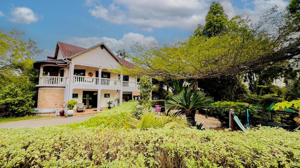 a large white house with a porch at Nature Kigali in Kigali