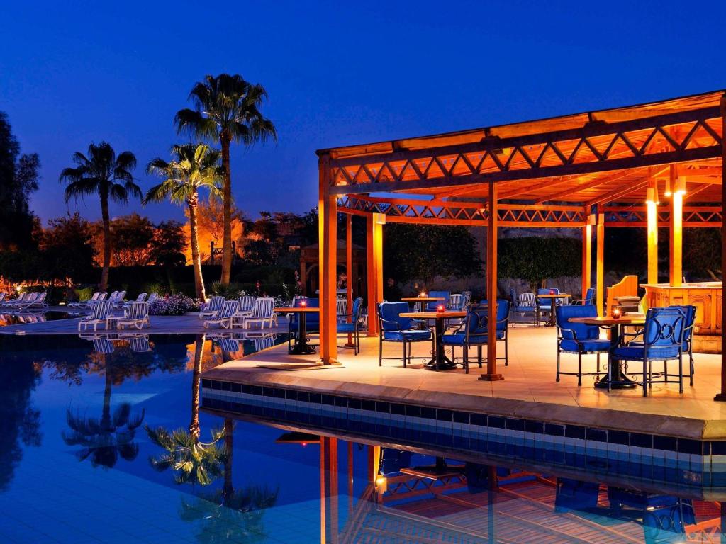 a patio with tables and chairs next to a pool at Naama Bay Promenade Beach Resort Managed By Accor in Sharm El Sheikh