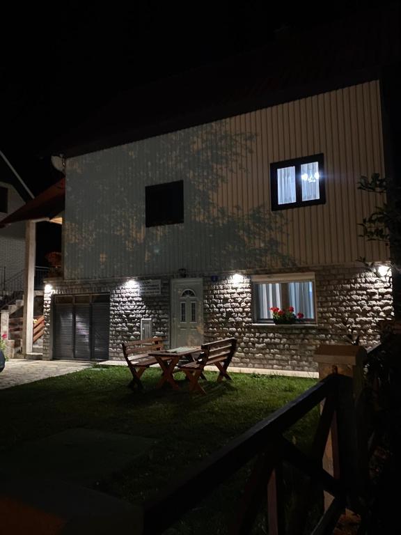 a bench in front of a building at night at Apartment VUK in Žabljak