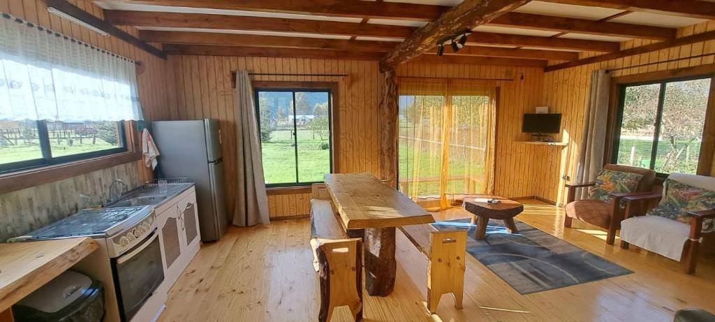 a kitchen with a wooden table in a room at Cabañas Llifén Costanera in llifen