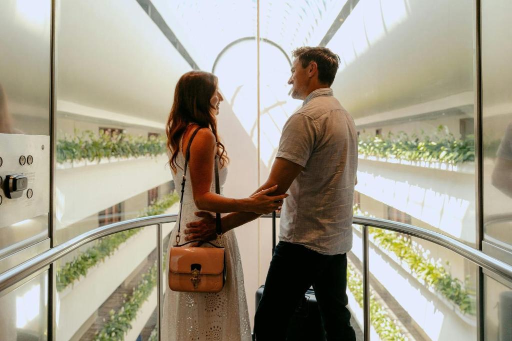a man and a woman standing in a building looking out the window at InterContinental Brisbane by IHG in Brisbane
