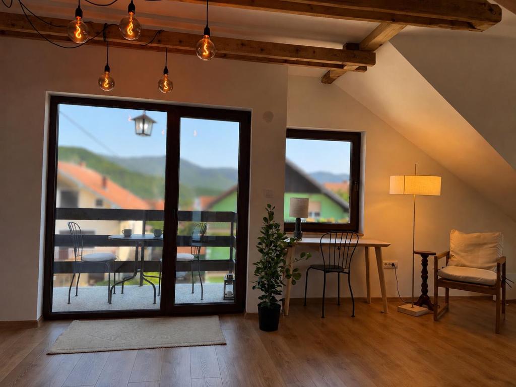 a living room with a table and a balcony at Dana apartment with Garden near Tara National Park in Bajina Bašta