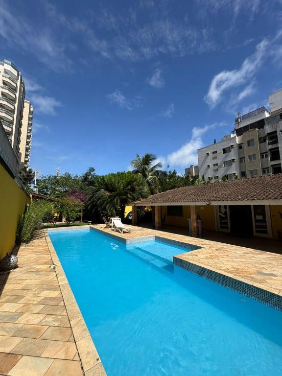 a large blue swimming pool in front of a building at Pousada Hostel Brazil Backpackers in Guarujá