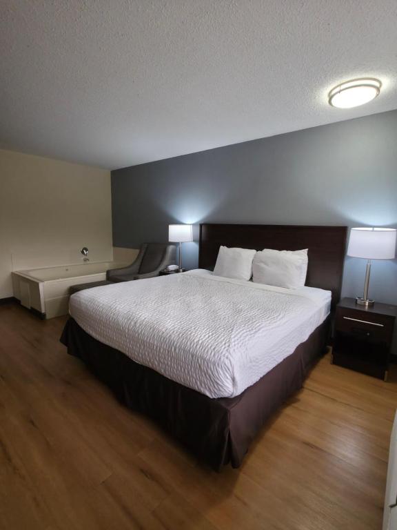 a hotel room with a large bed and two lamps at Americas Best Value Inn Moline in Moline