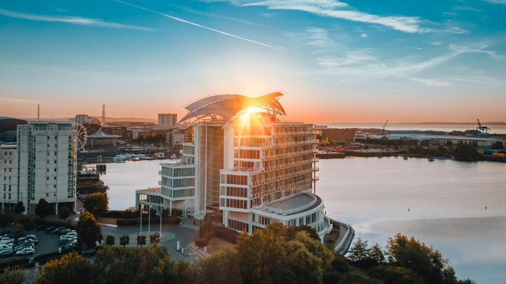 a city skyline with the sun shining on a building at voco St. David's Cardiff by IHG in Cardiff