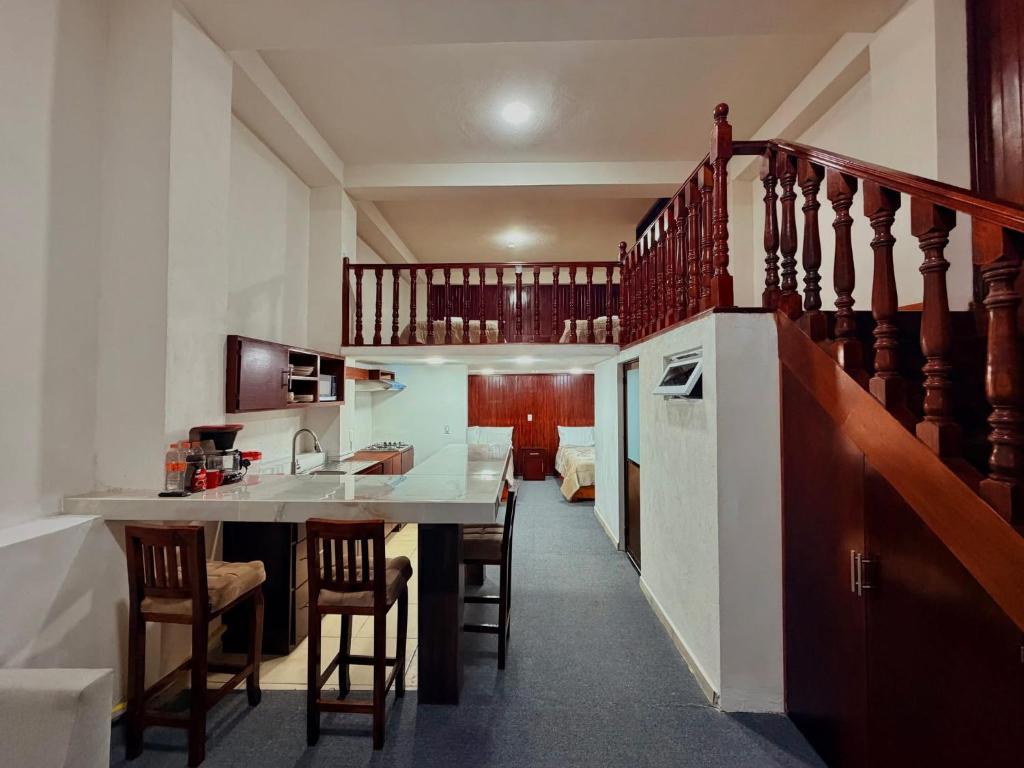 a kitchen with a table and chairs and a staircase at El encanto de Zacatlan in Zacatlán