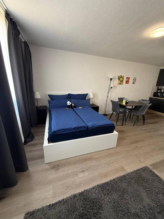 a bedroom with a bed with blue sheets and a table at Modern Apartment Close to Bus Station in Würzburg