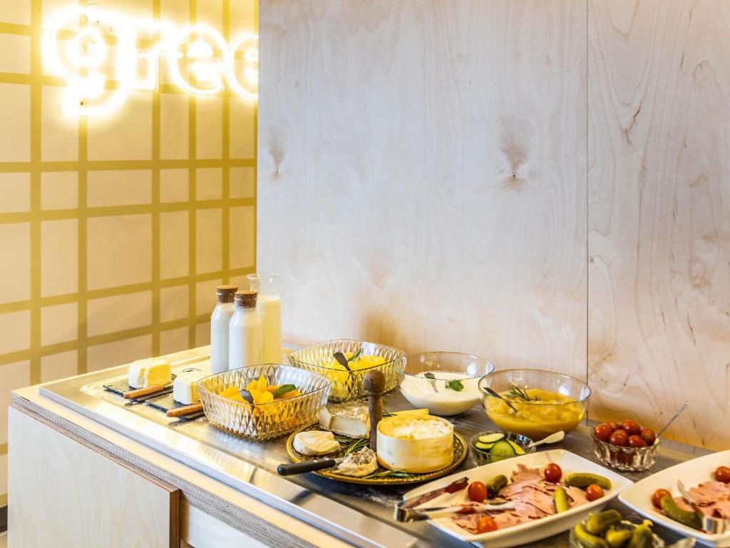 a table with many different dishes of food on it at greet hotel Marseille Parc Chanot Velodrome by Accor in Marseille