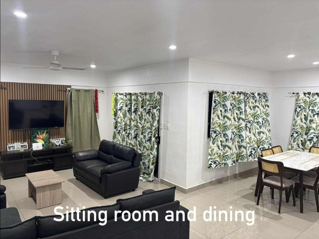 a living room with a couch and a dining room at NiNo in Vaitele