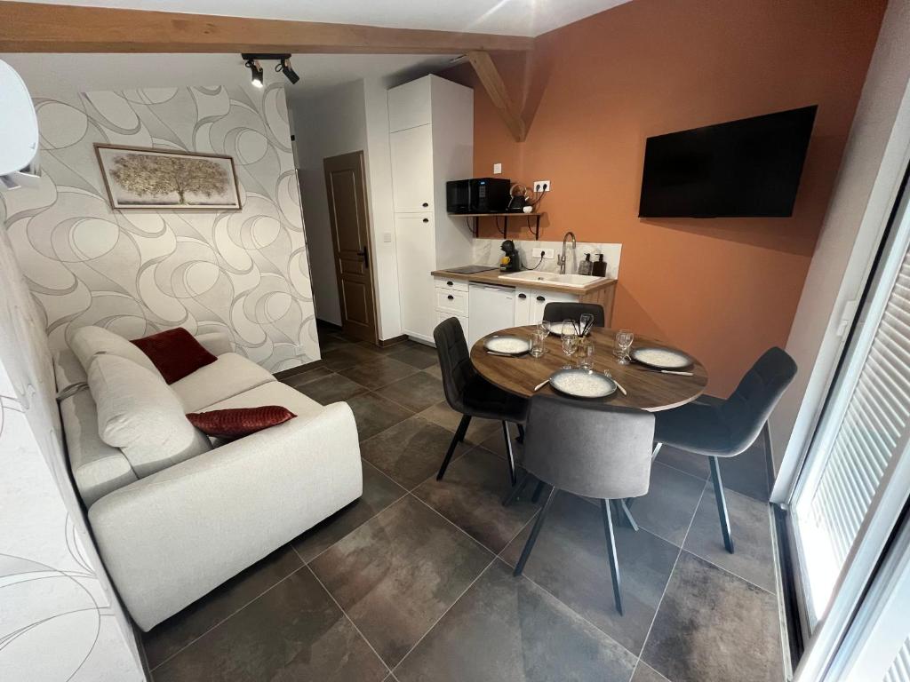a small living room with a table and a couch at L'Escale de Gaston in Sainte-Florence