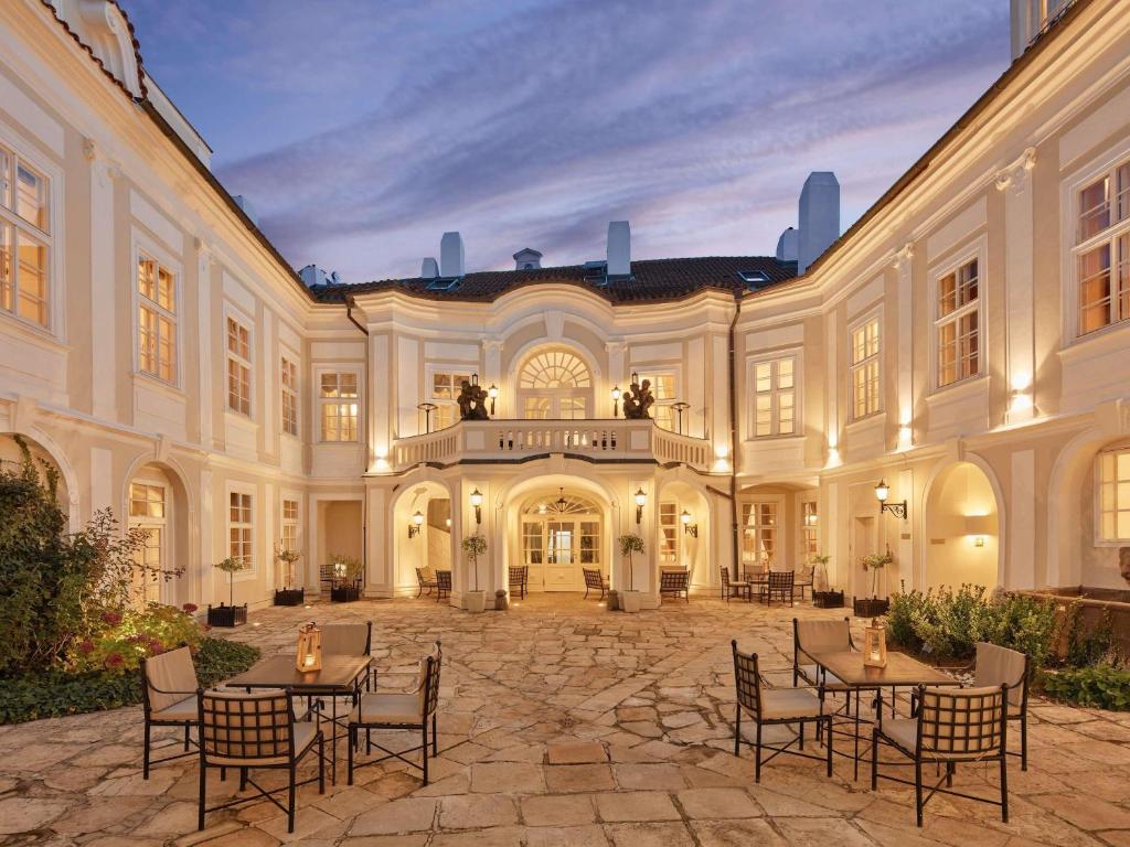 a large building with tables and chairs in a courtyard at The Mozart Prague in Prague