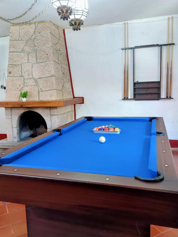 a blue pool table in a room with a fireplace at LA CASA DE DOÑA EMMA in Mazamitla