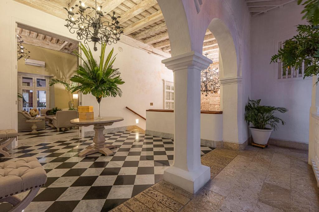 a lobby with a table and a checkered floor at Hotel Casa del Gobernador in Cartagena de Indias