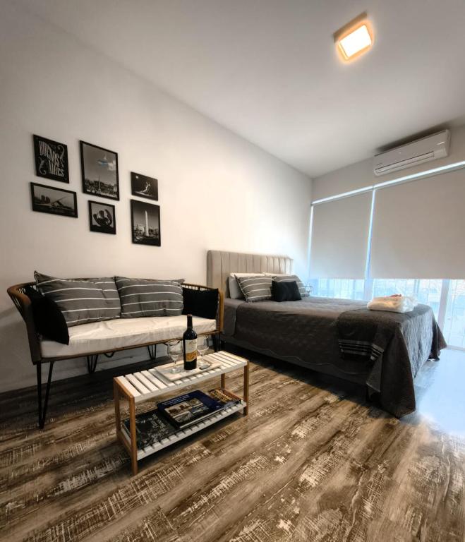 a bedroom with a bed and a couch and a table at @juanbjustoapartamento in Buenos Aires