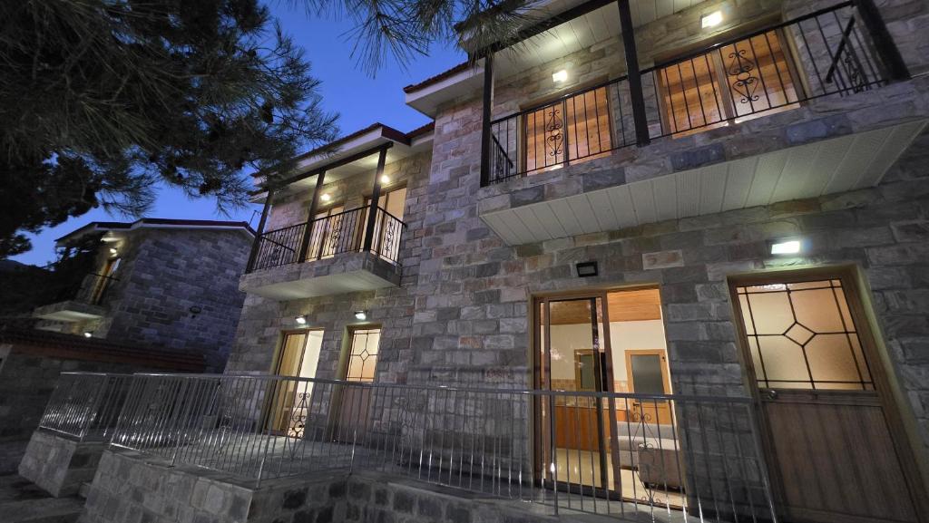 a large stone house with a balcony at night at Platres Villas in Kato Platres