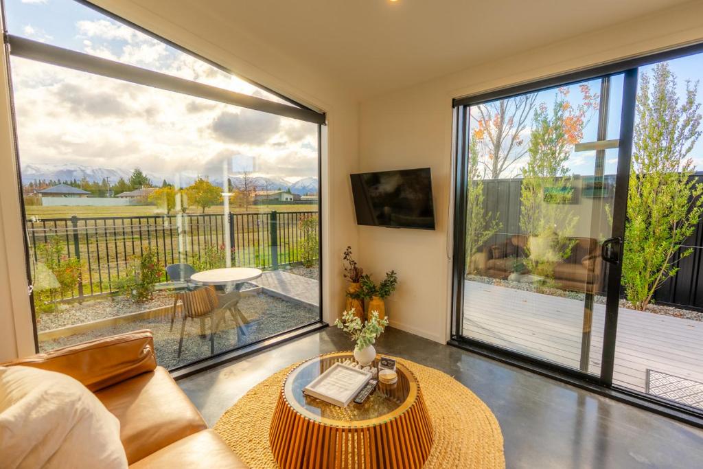 a living room with a couch and a large window at Ben Ohau Views The Studio in Twizel