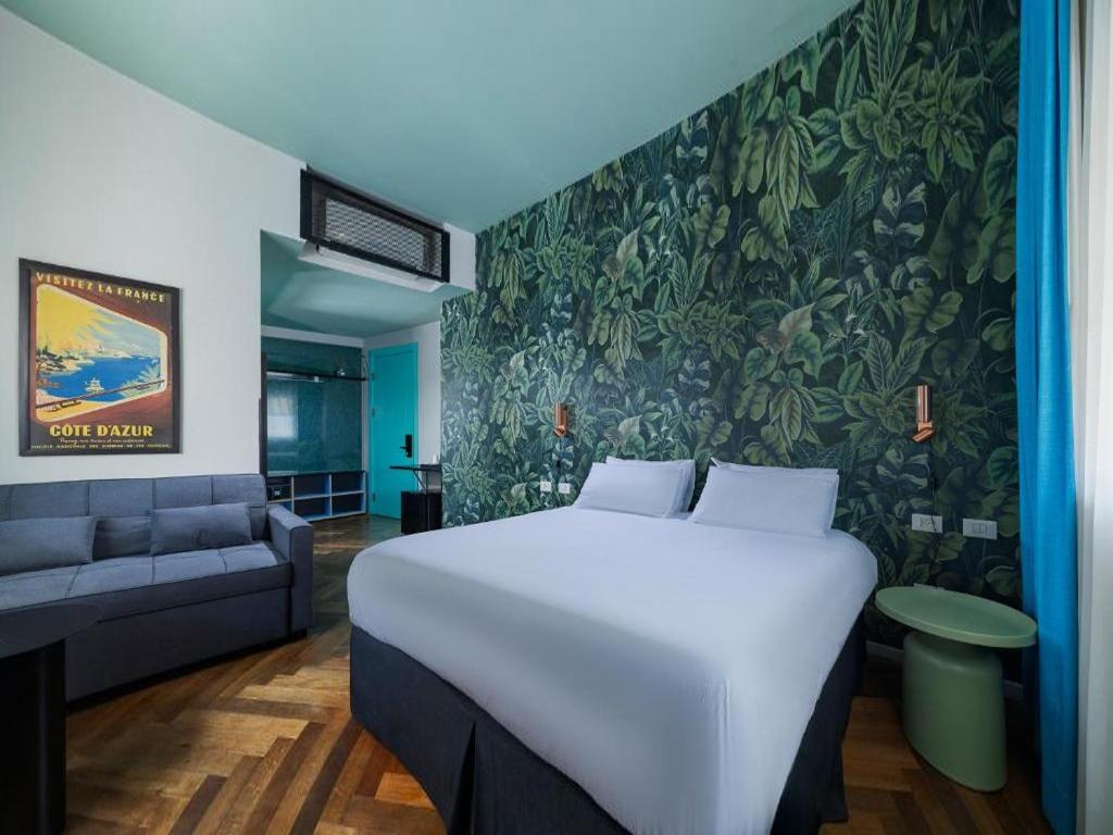 a bedroom with a large bed and a couch at Scarlet Hotel in Tel Aviv