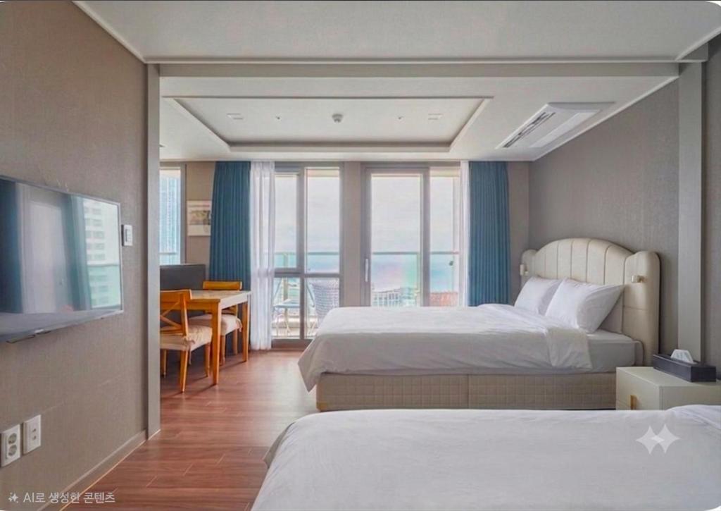 a hotel room with two beds and a table and a television at Flat nearby Heaundae beach in Busan