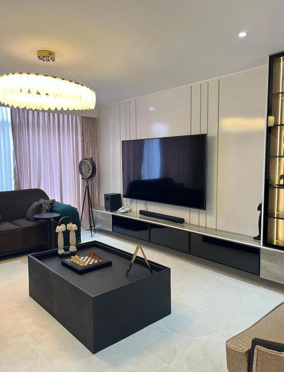 a living room with a large flat screen tv at NobleStaysTz in Dar es Salaam