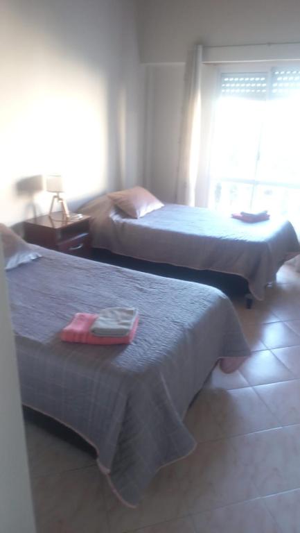 two beds in a hotel room with two beds sidx sidx sidx at Hostería Amancay in Merlo