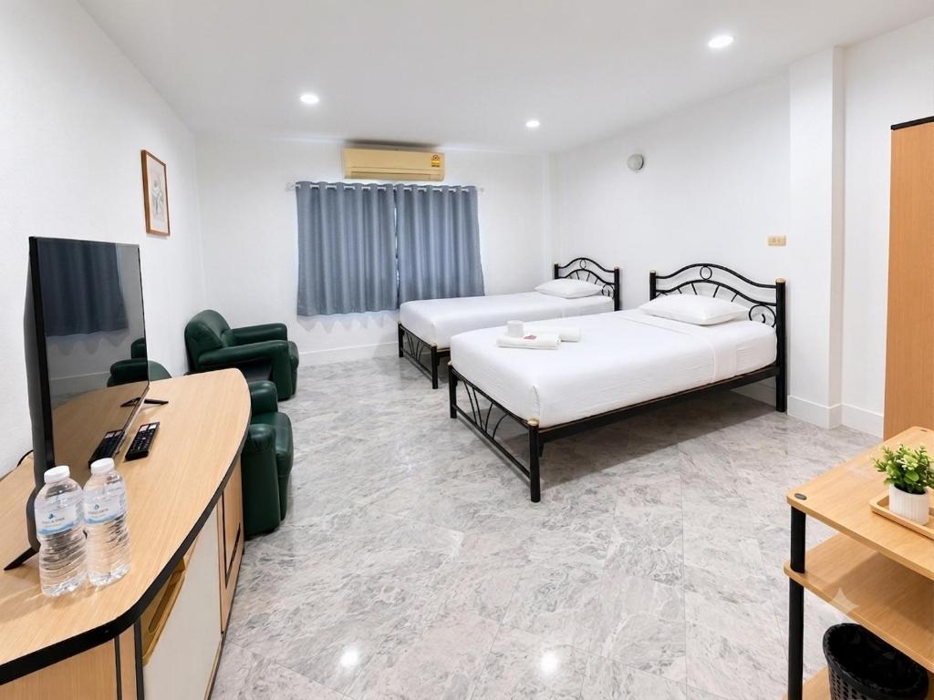 a hotel room with two beds and a tv at โรงแรมลักเซอรี่ Luxury Hotel in Kanchanaburi City
